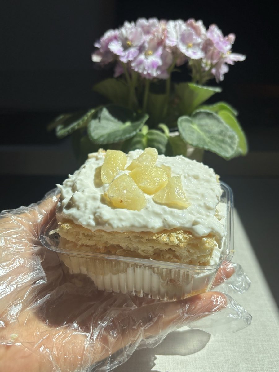 Fatia de bolo de abacaxi com coco e pedaços de abacaxi por cima