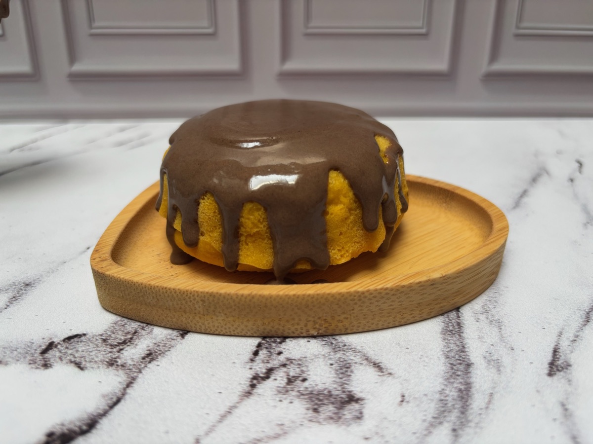 Mini bolo de cenoura com calda de chocolate, sobre bandeja de madeira